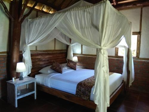 PenebelBali mountain forest cabin的一间卧室配有两张带天蓬的床