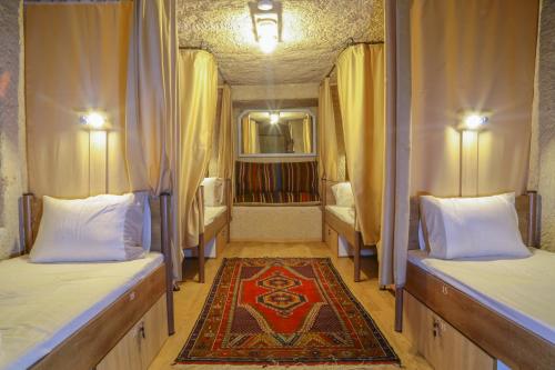 格雷梅Homestay Cave Hostel的一间设有两张床的房间和一张地毯