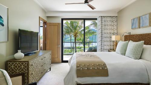 利胡埃Timbers Kauai Ocean Club & Residences的一间卧室配有一张大床和电视