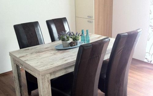 马尔泰洛弗卢拉霍夫酒店的餐桌、四把椅子和一张木桌(带盘子)