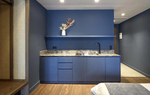 塞萨洛尼基Roomore Apartments的蓝色的厨房设有水槽和蓝色的墙壁