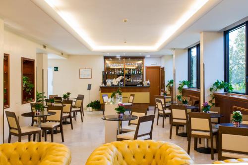 罗马Hotel The Brand的一间带桌椅的餐厅和一间酒吧
