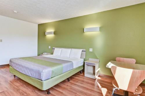 MoonEconomy Inn的一间卧室设有一张带绿色墙壁的大床
