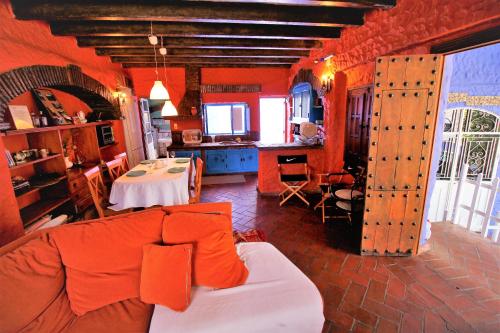 贝瑙卡斯Apartamentos Jaronil的客厅设有橙色墙壁、沙发和桌子