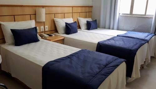 里约热内卢尤尼克酒店的酒店客房 - 带两张带蓝色枕头的床