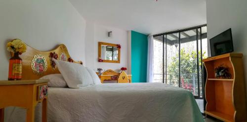 迪坡斯特兰HOTEL EL PAN NUESTRO的一间卧室设有一张床和一个大窗户
