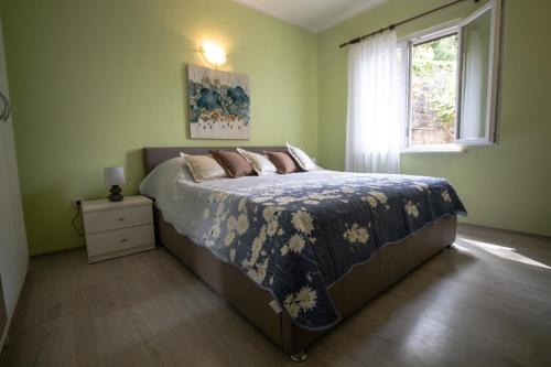 莫鲁纳特Apartment Jelena的绿色卧室内的一张床位,设有窗户