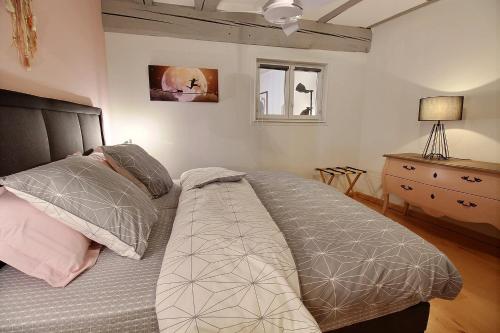 科尔马LE PTIT BARTHO的一间卧室配有一张床、一个梳妆台和一扇窗户。