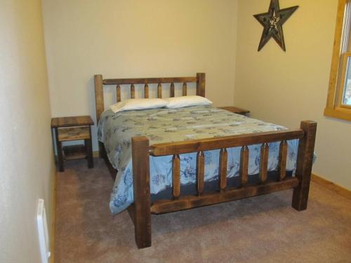 麋鹿城Mountain Man Cabin的卧室里的木床,墙上有一星星