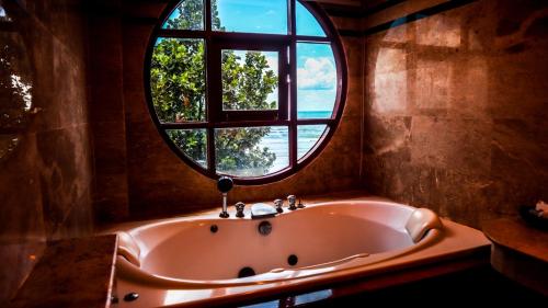 象岛麦克度假酒店的浴缸位于带圆形窗户的房间内