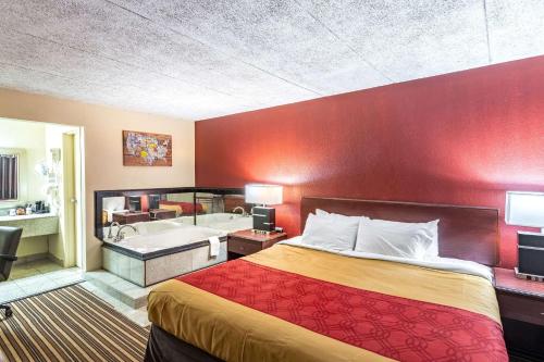 曾斯维尔曾斯维尔红屋顶酒店的酒店客房配有一张床和浴缸。