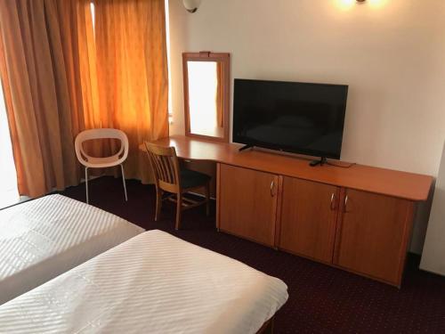 索瓦塔Pensiunea Tempo Sovata的酒店客房设有电视和一张带床铺的书桌