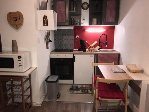 圣拉里苏朗studio saint lary soulan的一间带桌子和微波炉的小厨房
