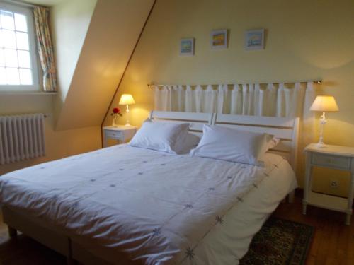 普卢格雷斯康LES AJONCS的卧室配有一张带白色床单和枕头的大床。