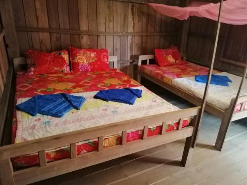 邦隆Bee Bee's Chalets home stay and trekking的木墙客房的两张床