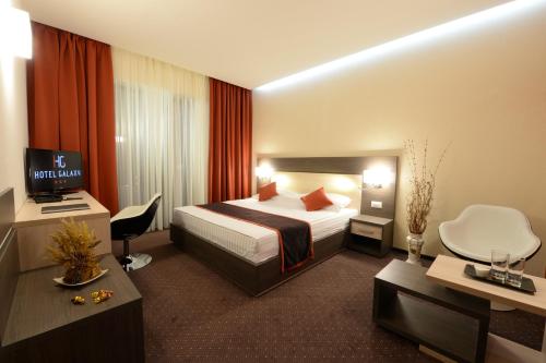 蒂米什瓦拉银河酒店的配有一张床和一张书桌的酒店客房