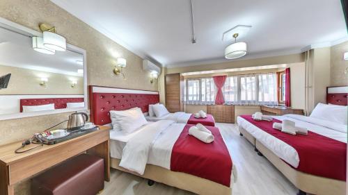 伊斯坦布尔Cihangir Palace Hotel的酒店客房,设有两张床和镜子