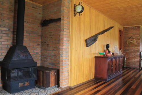 乌鲁比西Casa da Montanha的一间设有炉灶的房间,一间女宾坐在房间里