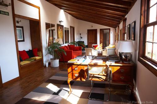 伊科德洛斯维诺斯Platanera Suites的客厅配有书桌和红色沙发