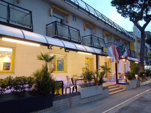 里乔内Hotel Marzia con Piscina的前面有椅子和植物的建筑
