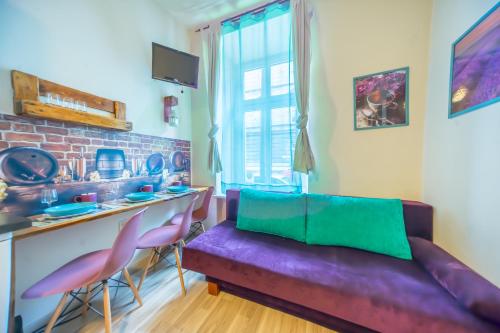 克拉科夫埃迪拉公寓酒店的客厅配有紫色沙发和粉红色椅子
