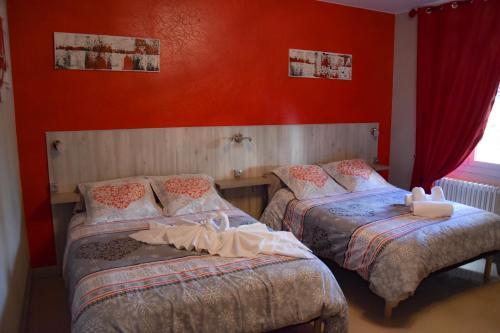 洛特河畔的维伦纽夫德斯公寓酒店的红色墙壁客房的两张床