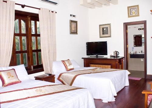 潘郎格洛德鲁斯特度假酒店的一间卧室配有两张床和电视。
