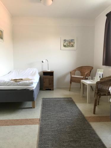BoarpHillesgården的卧室配有1张床、1张桌子和1把椅子