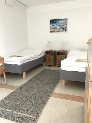 BoarpHillesgården的配有两张桌子和地毯的房间的两张床
