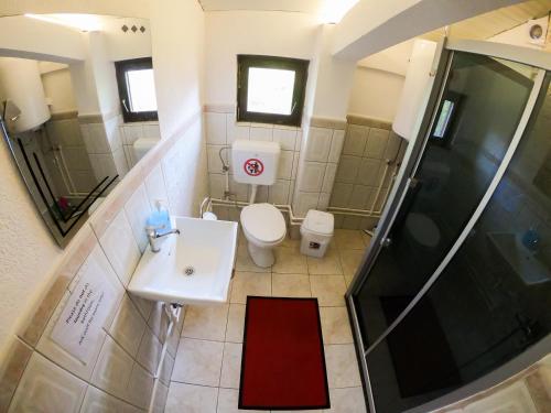 佩奇Sarac Hostel的浴室配有卫生间、盥洗盆和淋浴。
