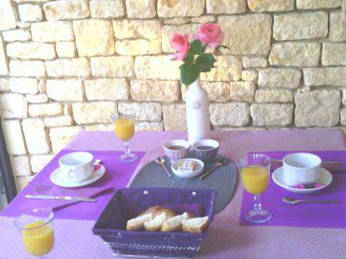 拉罗克加雅克克洛斯盖尔拉朵酒店的紫色桌子,盘子上放着糕点和橙汁