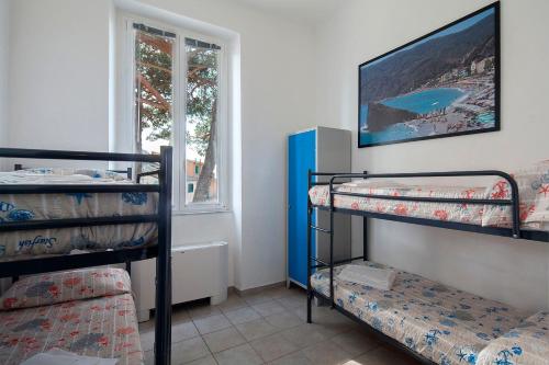 克里日亚Ostello Corniglia的客房设有三张双层床和一扇窗户。