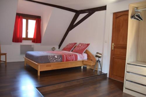 利克维P'tit Biscuit的一间卧室配有一张带红色窗帘的床和一扇窗户