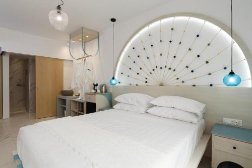 法里拉基Mylos Luxury Escape的卧室配有一张白色的床和大型床头板