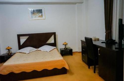皮特什蒂Hotel Sorelo的一间卧室配有一张大床和一个梳妆台