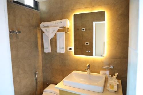 亚的斯亚贝巴Vamos Addis Hotel的一间带水槽、卫生间和镜子的浴室