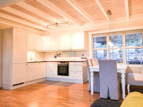 斯屈勒斯塔穆Voss - Apartment with panoramic view的厨房配有白色橱柜和桌椅
