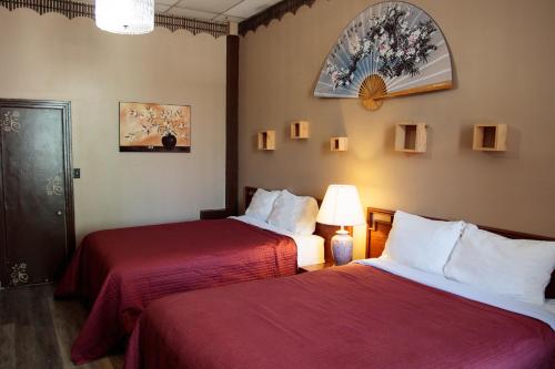 蒙特利尔贝拉之屋酒店的酒店客房,配有两张带红色床单的床