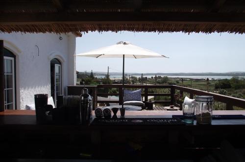 福斯·杜·阿勒奥Sunshine Hostel的露台顶部的桌子和遮阳伞