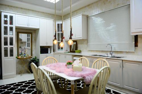 阿吉曼Kaleidoscope的厨房配有带粉色桌布的桌子