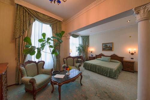 瓦尔纳伦敦格兰酒店的酒店客房带一张床、一张桌子和椅子