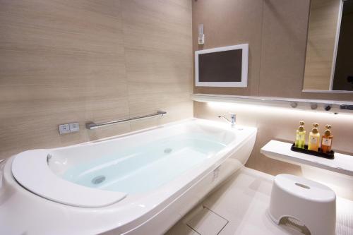 淡路托托海风淡路酒店的白色的浴室设有浴缸和卫生间。