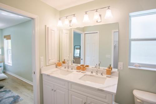 萨尼贝尔Stunning Newly Designed and Renovated Home seconds to the Gulf Of Mexico的一间带两个盥洗盆和大镜子的浴室