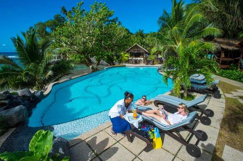 奥法加Seabreeze Resort Samoa – Exclusively for Adults的一群人坐在游泳池旁的草坪椅上