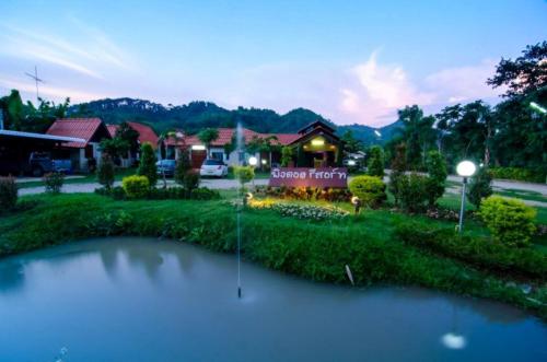 Ban Dong Ma Tun平多伊度假酒店的房屋前有池塘的房子