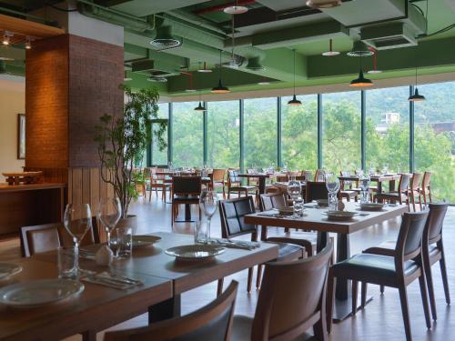 台北有诚商旅的用餐室设有桌椅和窗户。