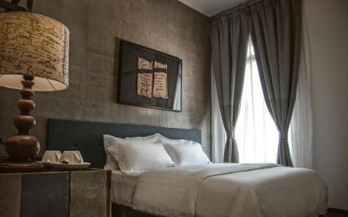 怡保怡保默顿酒店的一间卧室配有床、灯和窗户