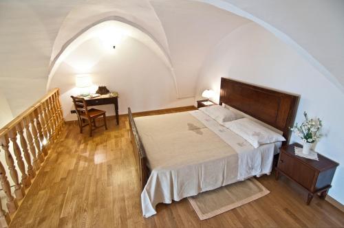 SupersanoHome Holiday Salento Casa Agrosì的一间卧室配有一张床、一张桌子和一张书桌