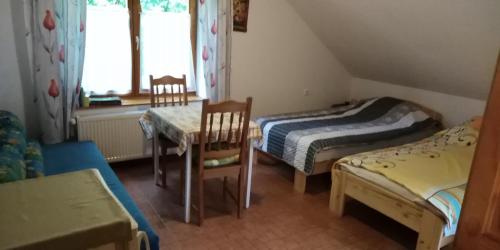 多博戈科Dobogókő vendégház的一间设有两张床和一张桌子及椅子的房间