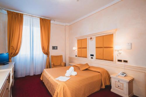 基安奇安诺泰尔梅米兰大酒店的酒店客房,配有床和电视